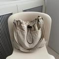 Beige Leichte Nylon-Beuteltasche mit Kordelzug und Fronttasche auf einem weißen Stuhl - Khaki