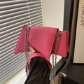 Fuchsia geometric shoulder bag with silver chain strap shown in a modern home setting - Rose Pink