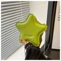 Macro shot of neon green star-shaped crossbody bag with silver chain and stitched edges - Green