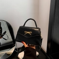Glanzende zwarte laks lederen crossbody tas met gouden metalen strik en handvat - Zwart