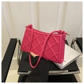 Primer plano detallado de bolso fucsia acolchado con rombos y herrajes metálicos dorados - rosa intenso