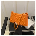 Close-up of orange quilted shoulder bag with fine strap and metallic details - Orange