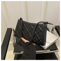 Detalle de bolso de hombro acolchado negro con correa trenzada y terminales metálicos - Negro