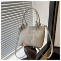 Detalle de bolso bucket gris en cuero con asa anudada y correa de hombro ajustable - Plateado