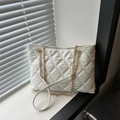 Elegante borsa tote trapuntata bianca con catene dorate su un davanzale della finestra - Bianco