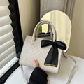 Chic cream woven tote bag with a black ribbon bow charm and adjustable crossbody strap - Gray
