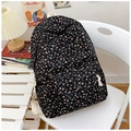 Floral nylon backpack for women with pink tulip print on black fabric shown on a chair - Black