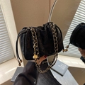 Elegante schwarze Samt-Beuteltasche mit goldener Kette in einer Spiegelreflexion - Schwarz