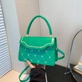 Green quilted handbag with heart pattern featuring a round top handle and crossbody strap - Green
