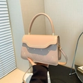 Pink quilted crossbody bag with heart embroidery and top handle in a soft indoor setting - Khaki