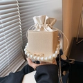 Beige woven bucket bag with pearl handle and golden chain strap in a casual style - Khaki