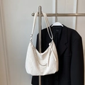 Borsa hobo bianca con catena d'argento presentata su uno sfondo di blazer nero moderno - Bianco Sporco