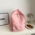 Pink minimalist school backpack with white braided zip puller in a clean indoor setting - Pink
