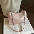 Bolso rosa de media luna con cadena plateada sobre fondo de libro vintage - Rosa