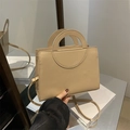 Bolso bandolera beige minimalista con asa circular y acabado en cuero liso - Caqui