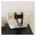 Primer plano de un bolso tote blanco con detalles en negro y letras grabadas FASH - Blanco