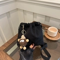 Borsa a secchiello in nylon nero a pieghe con ciondolo peluche e tracolla larga - Nero Con Pendente