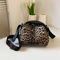 Borsa a tracolla leopardata con cinturino nero su una scrivania bianca minimalista - Cachi
