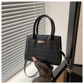 Detalle de bolso negro de piel sintética con grabado de cocodrilo y herrajes dorados - Negro