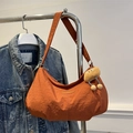 Chic orange crescent tote bag in textured nylon with a cute plush charm and fashion patch - Orange With Pendant