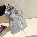 Bolso tipo saco gris claro plisado con cordón ajustable, ojales metálicos y tela suave - Gris