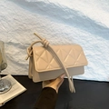 Beige gesteppte Klappentasche mit Knotengurt und goldenen Metallteilen in der Hand - Khaki