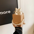 Beige woven bucket bag with pearl handle, drawstring liner, and gold chain strap - Khaki
