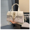 Détail du sac blanc en cuir avec texture crocodile, logo doré et élégant pendentif à franges - Blanc