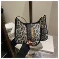 Detalle de bolso leopardo con cadena dorada y ribete negro sostenido por modelo - Negro