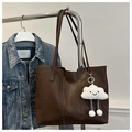 Detail of dark brown tote bag with plush cloud charm hanging on a metal rack - With Cloud Pendant / Coffee