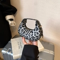 Mini crescent handbag featuring a bold leopard print pattern and gold zipper detail - Black