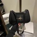 Borsa minimalista in pelle nera sottobraccio con stella argento su superficie liscia - Nero