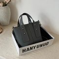 Minimalistische schwarze Leder-Beuteltasche mit Litschi-Struktur und goldenen Beschlägen - Grau