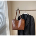 Detail of adjustable silver buckle on a brown oil wax leather large tote bag - Coffee