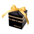 Detail of a black Mubarak gift box with gold ribbon and geometric foiling patterns - Black Box + Gold Ribbon