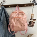 Detail of pink floral mini backpack featuring multi-zipper pockets and nylon fabric - Little Floral / Pink