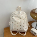 Detail of floral mini backpack on a wooden table with vintage decor and soft lighting - Little Floral / White