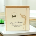 Vintage kraft paper greeting card with bronze metal bow and rustic twine decoration - Bowknot Style