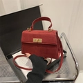 Detalle del bolso bandolera burdeos en ante sintético con cierre dorado de metal - Rojo
