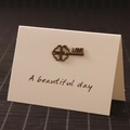 Chiave vintage a quadrifoglio in bronzo con incisione LOVE su biglietto bianco - Chiave