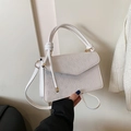 Detail of white embossed small square bag featuring clover pattern and gold metal clasp - White