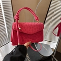 Detail of embossed rose red crossbody bag with a chunky knotted handle and gold hardware - Pink