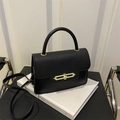 Details der schwarzen Leder-Boxtasche mit Litschi-Textur und goldenem Kettenschloss - Schwarz