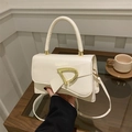 Detail of the chic beige PU leather handbag featuring a stylish bow and gold D-ring buckle - White