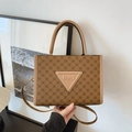 Detail van bruine shopper met geometrische patronen, leren logo-patch en handvatten - Bruin
