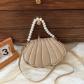 Bolso concha dorado champán con asa de perlas y textura brillante sobre seda suave - Dorado