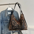 Dettaglio della borsa tote leopardata con applicazione a farfalla su un gancio - Marrone Scuro