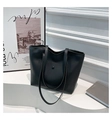 Detalle del bolso tote de cuero negro mate con hebilla metálica redonda y bolsillo frontal - Negro