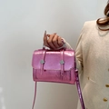 Bolso mensajero rosa metalizado con textura arrugada y botones plateados en mano - Rosa