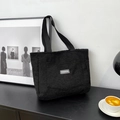 Minimalist black plush tote bag with FASHION label and durable woven strap handle - Black